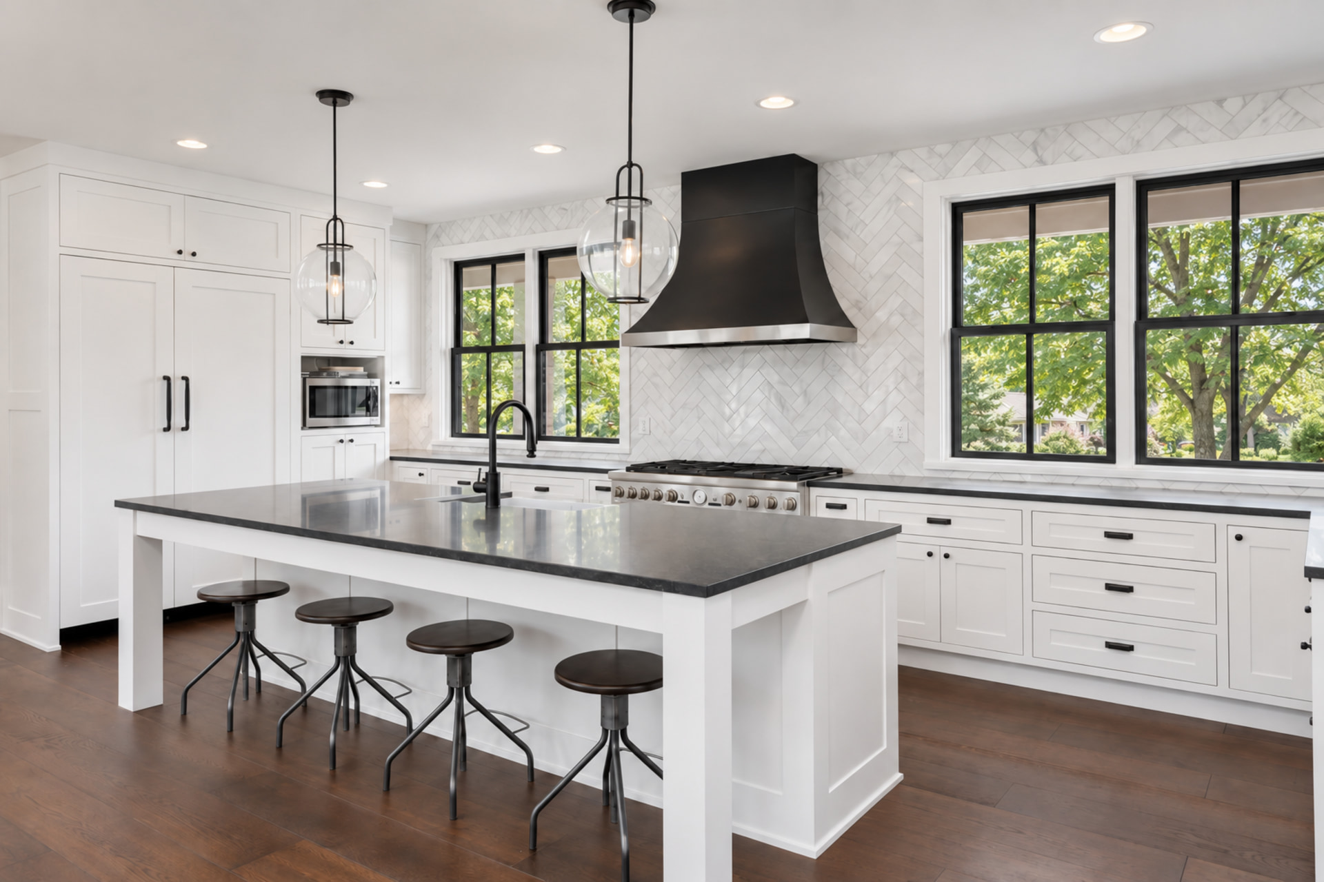White shaker kitchen remodel with custom black range hood, center island, and hardwood floors, Sioux Falls SD